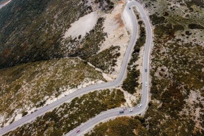 Captivating aerial shot of a winding road through autumn landscapes on a mountain.
