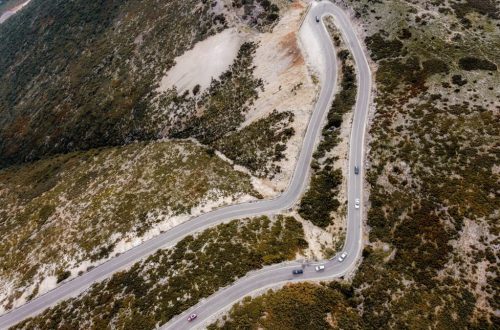 Captivating aerial shot of a winding road through autumn landscapes on a mountain.