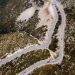 Captivating aerial shot of a winding road through autumn landscapes on a mountain.